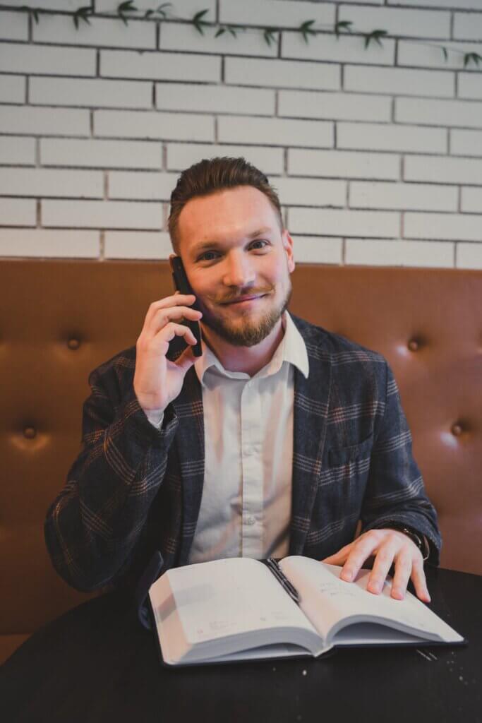 Jakub Kratochvíla telefonuje s klientem nad poznámkami