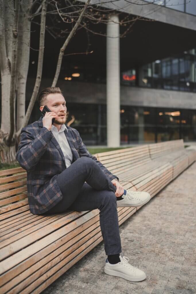 Jakub Kratochvíla telefonuje na lavičce před kanceláří